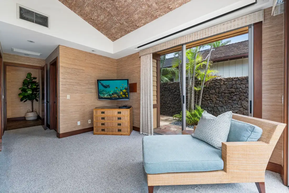 A bright sitting room with sliding glass doors opening onto a small patio.