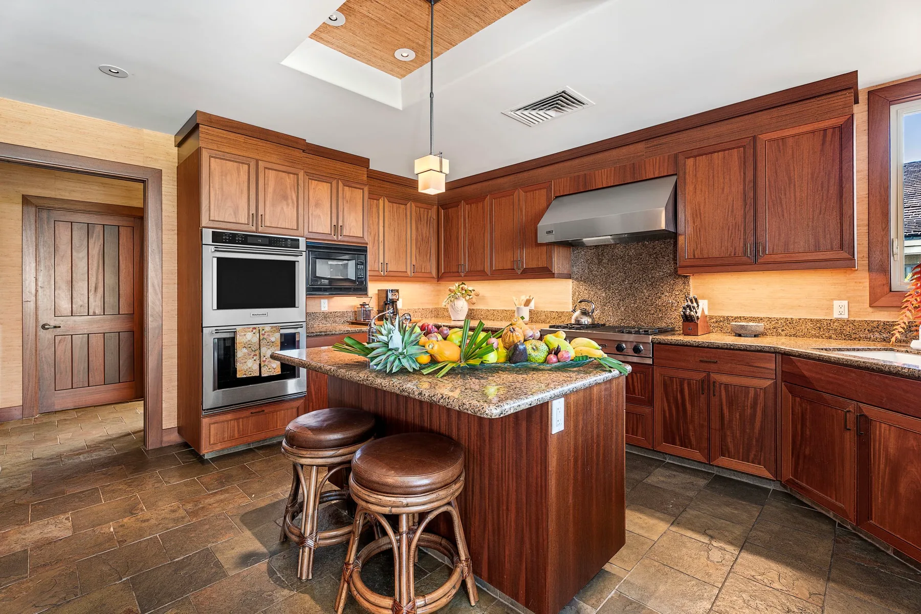 A spacious kitchen with wooden cabinets, built-in appliances, and a central island.