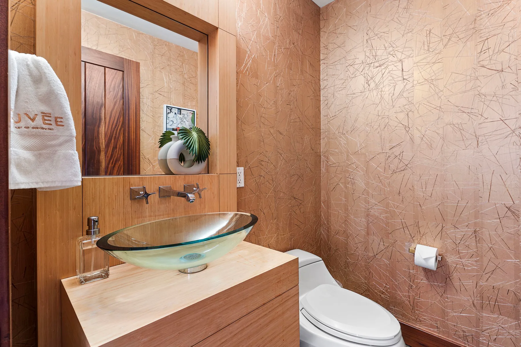 A bathroom with a vessel sink, wall mirror, and toilet.