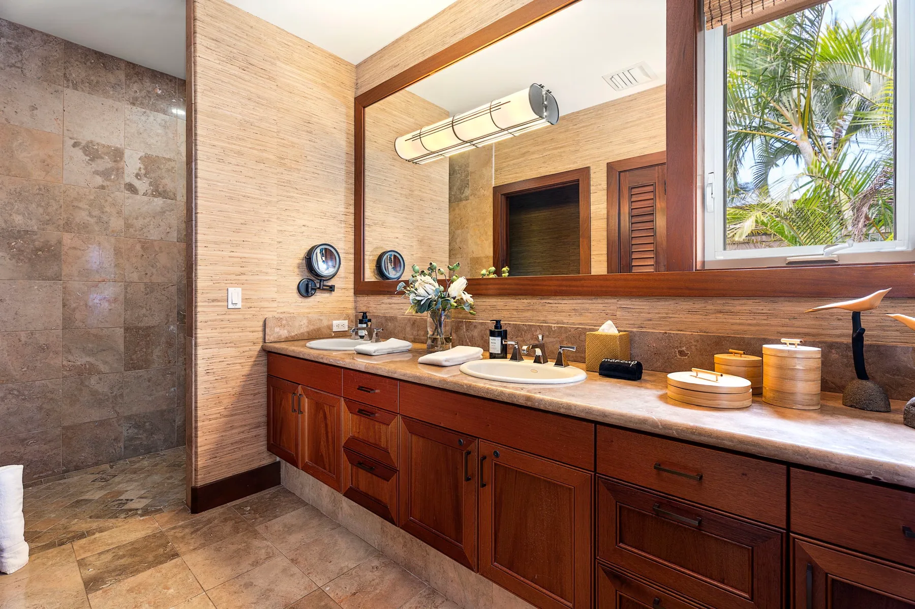 A bathroom vanity with a broad mirror, countertop, and wooden cabinets.