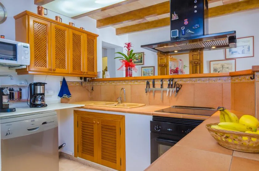 A kitchen with wooden cabinets, a countertop, and cooking appliances.