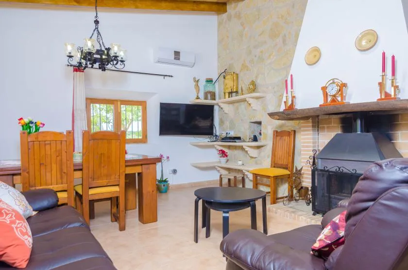 A living and dining room with seating, a dining table, and a fireplace.
