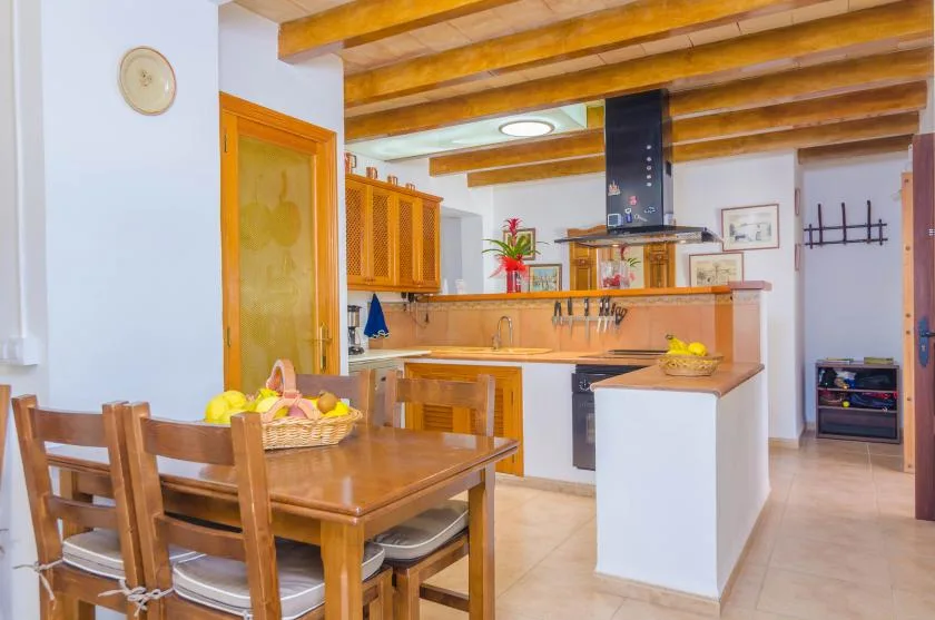 A kitchen and dining area with wooden cabinets and a table.