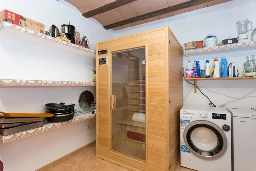 A laundry room with a wooden sauna and washing machine.