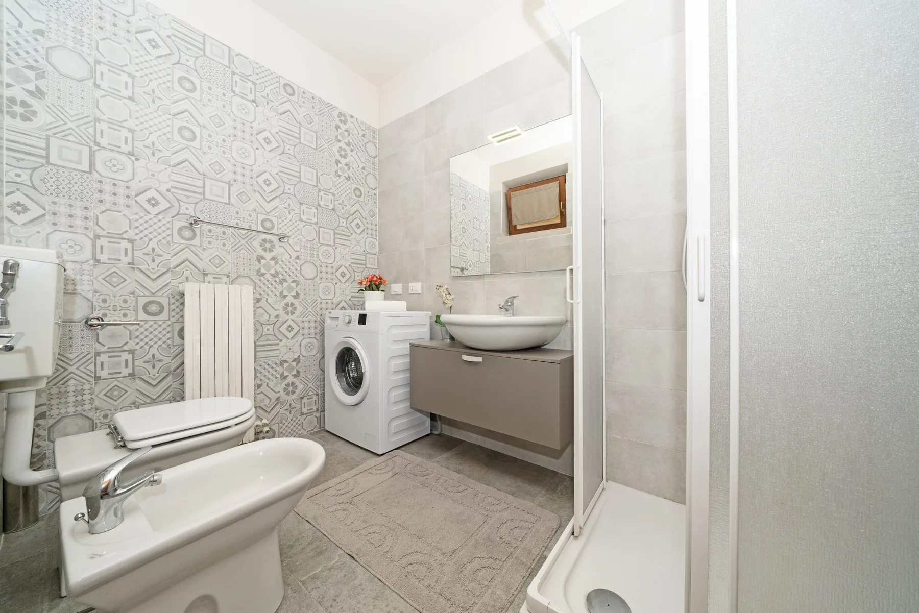 A bathroom with a toilet, sink, and washing machine.