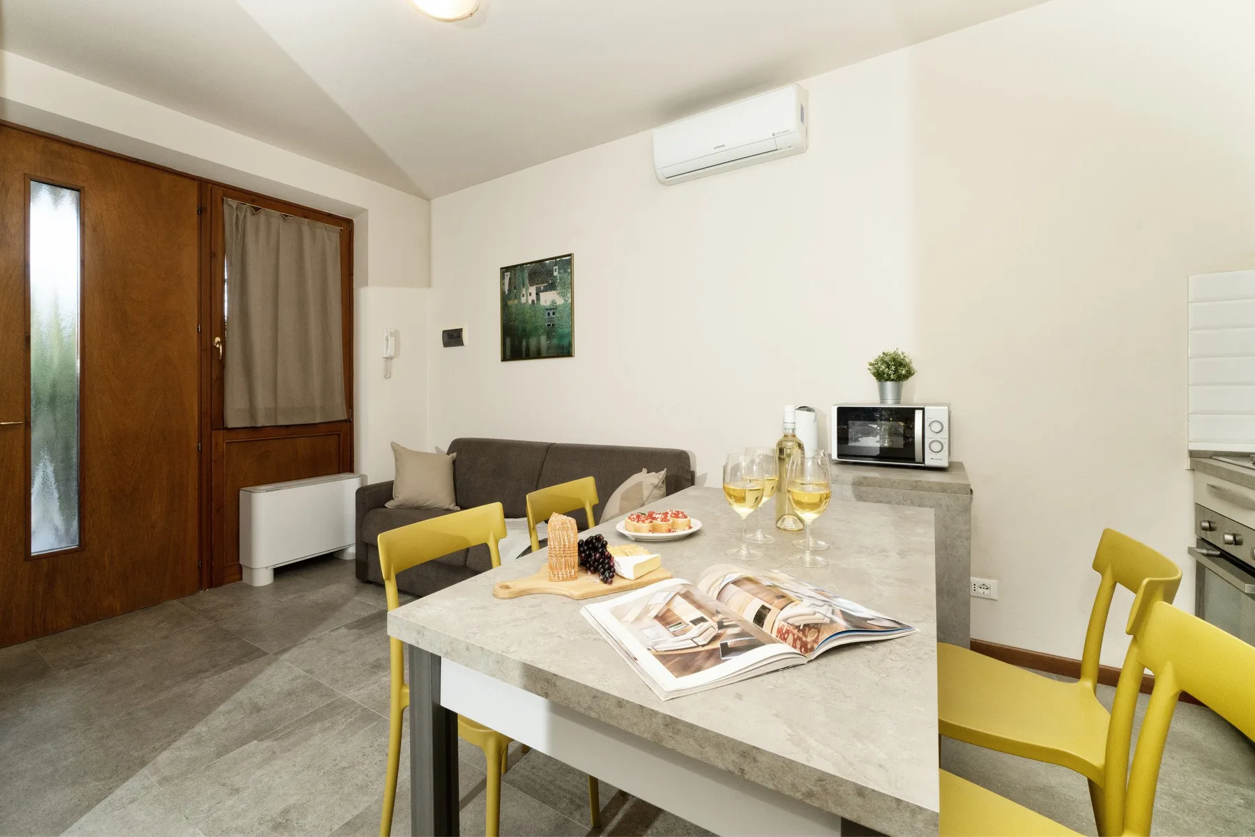 A dining area with yellow seating and a table set with food and magazines.