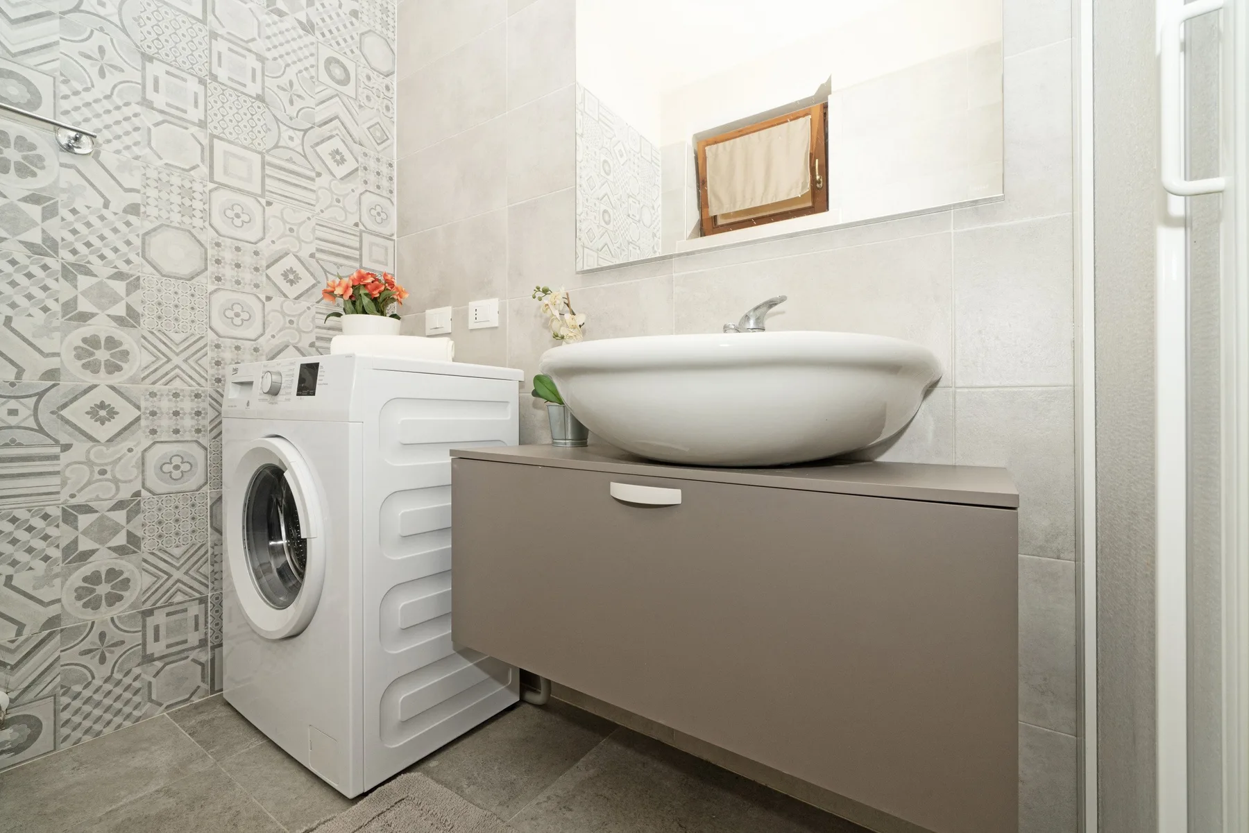 A bathroom vanity with a vessel sink stands beside a washing machine.