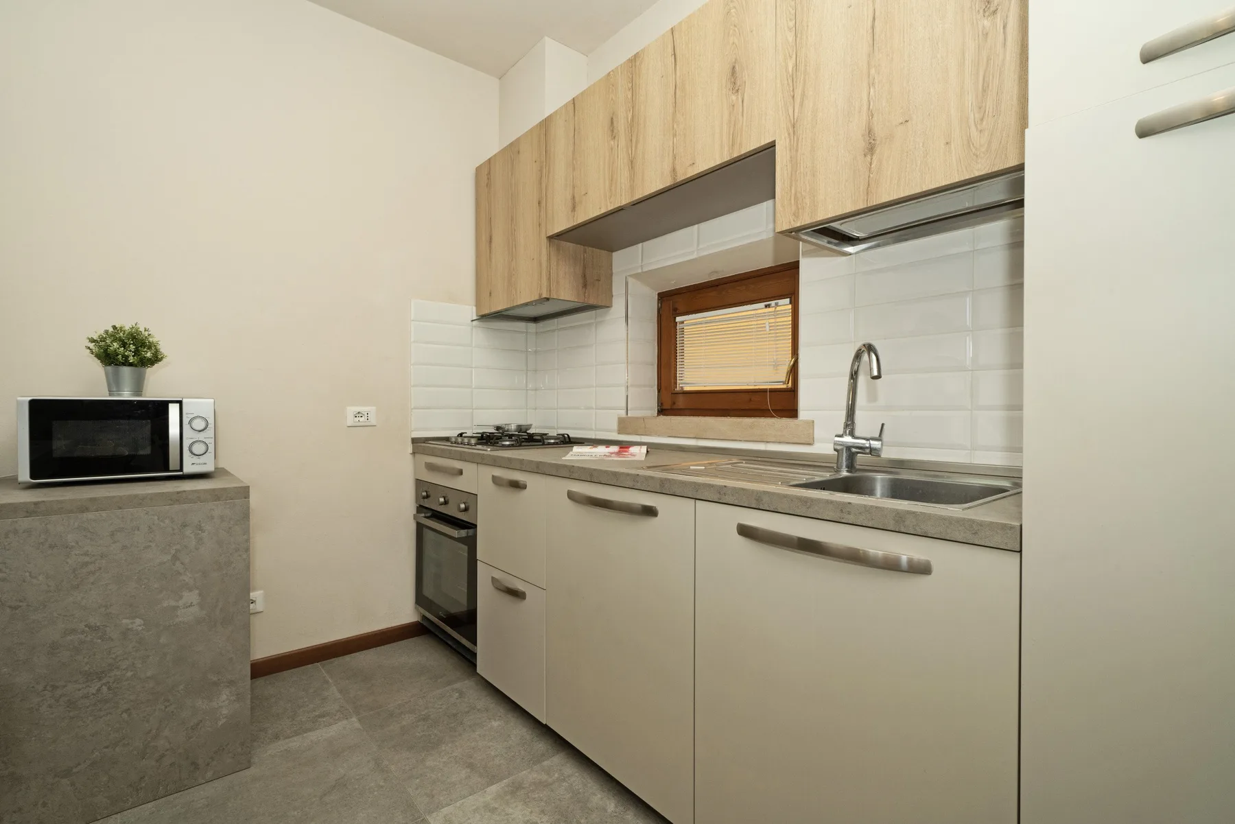 A compact kitchen with a countertop, cooktop, oven, and sink.