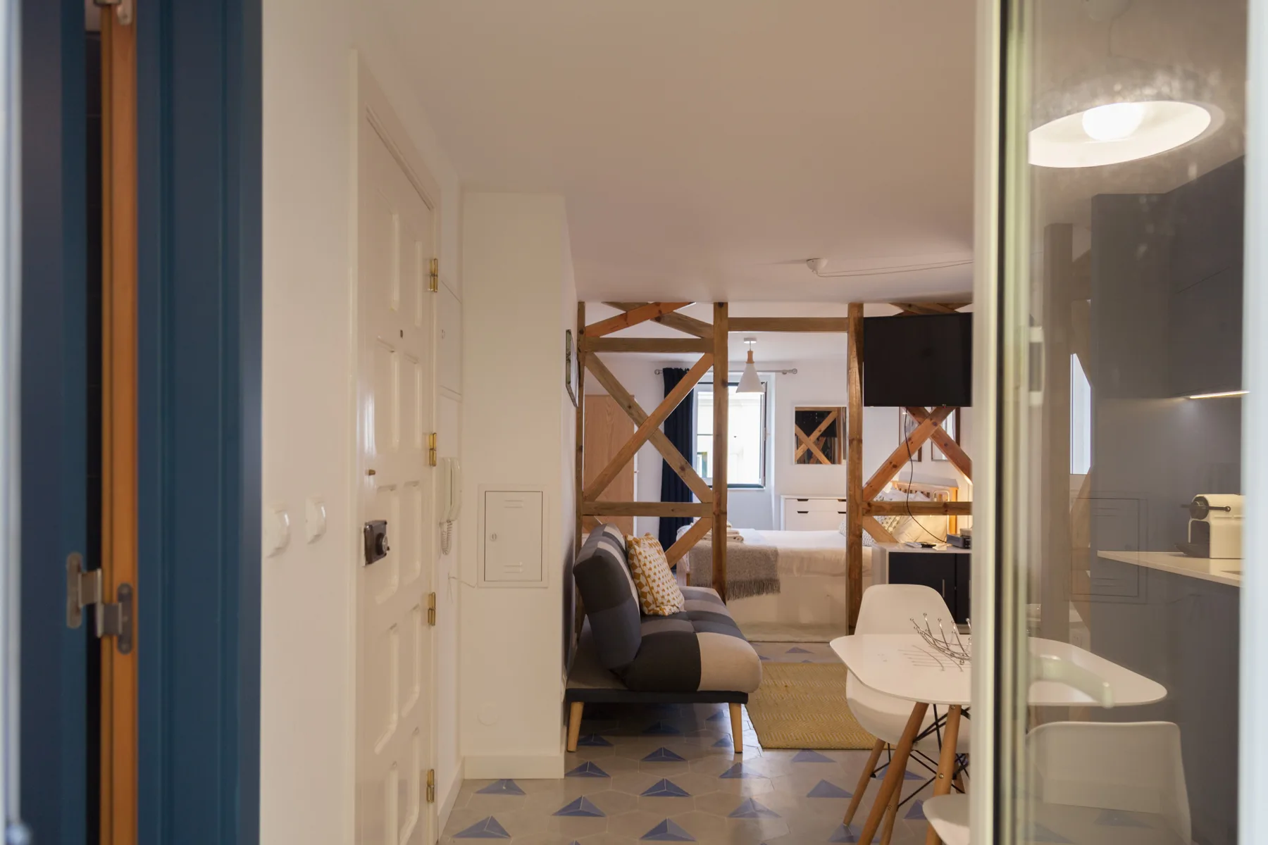 Un estudio con zona de estar y una cama al fondo.