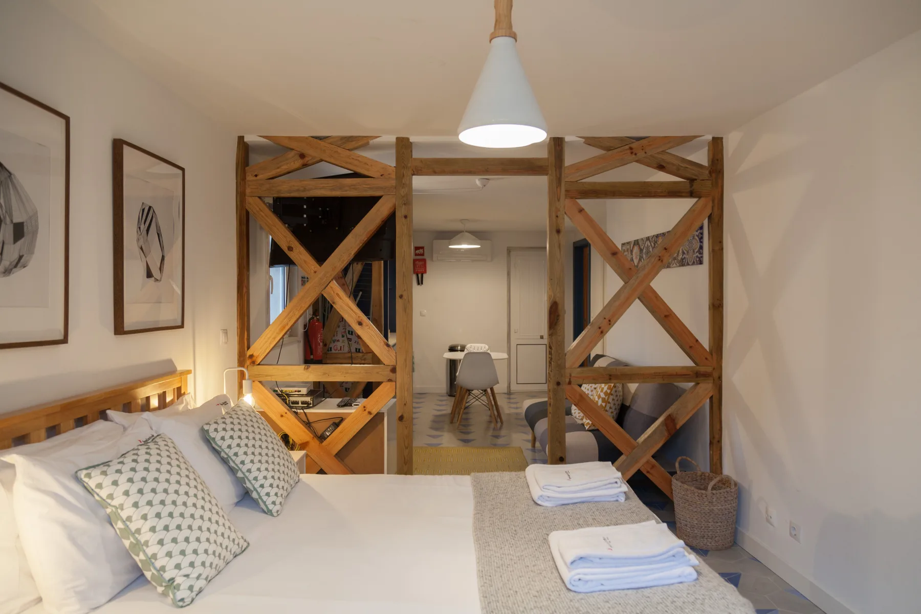 Un dormitorio con una cama, cuadros enmarcados y paneles de madera.