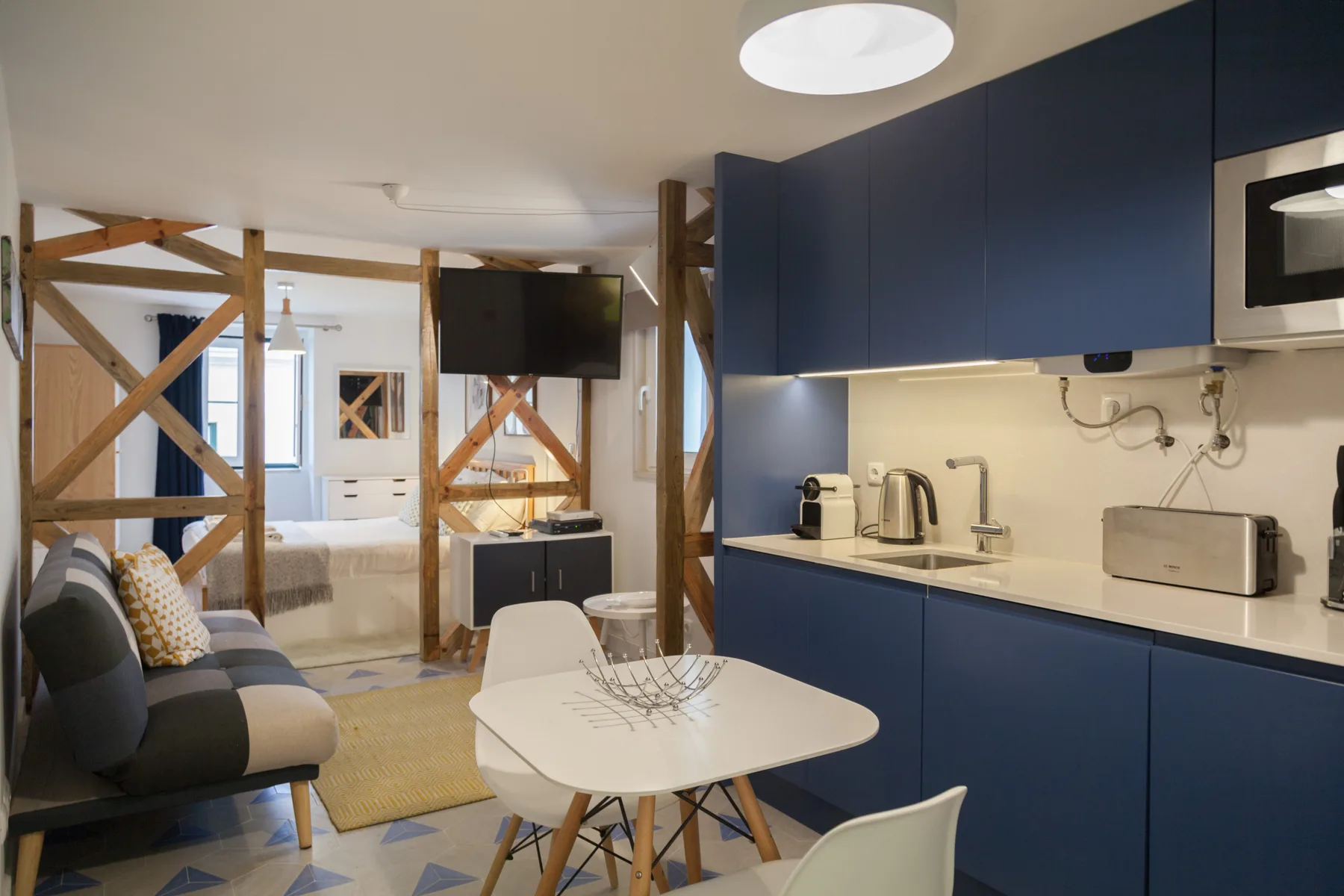 Una sala de estudio compacta con cocina pequeña y mesa de comedor.