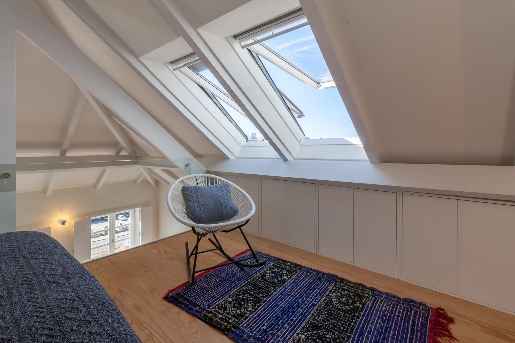 A bright loft seating area with sloped ceilings and large skylights.