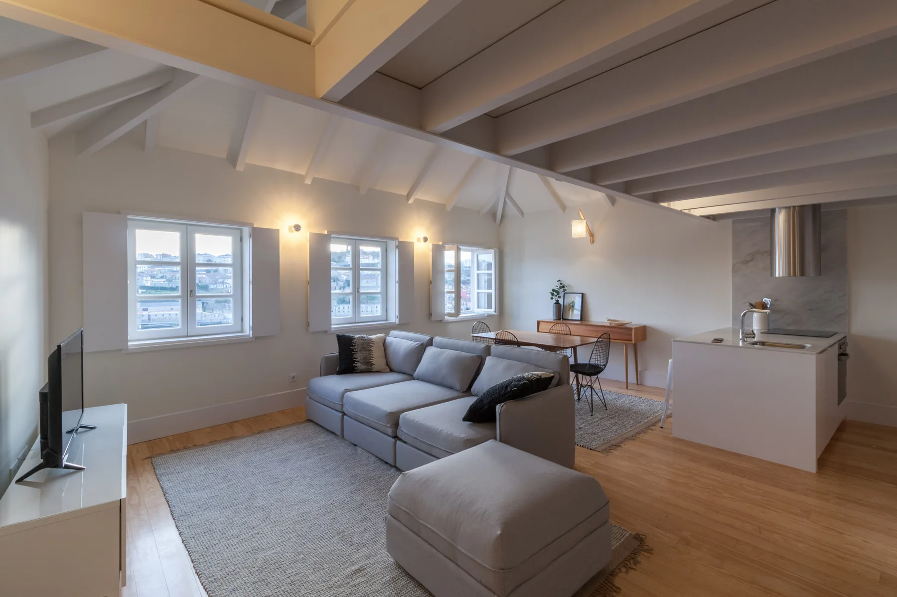 An open-plan living area with seating, a dining table, and a kitchen.