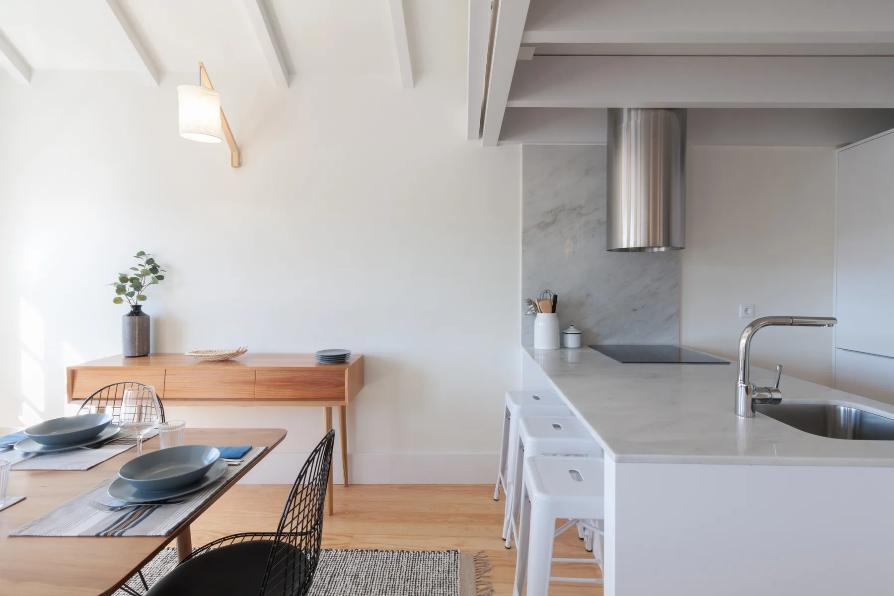 A bright dining area opens onto a modern kitchen with a long island.