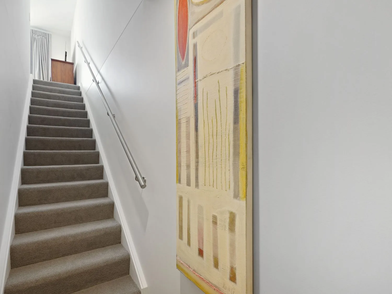 Una escalera alfombrada con un pasamanos de metal y un cuadro abstracto en la pared en Modern Central Apartment - Christchurch Apartment, en Monavale