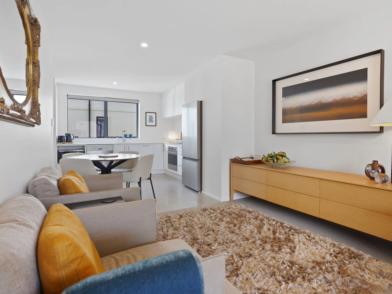 Una sala de estar con sillones y una alfombra de pelo largo junto a una mesa de comedor y una cocina en Modern Central Apartment - Christchurch Apartment, en Monavale