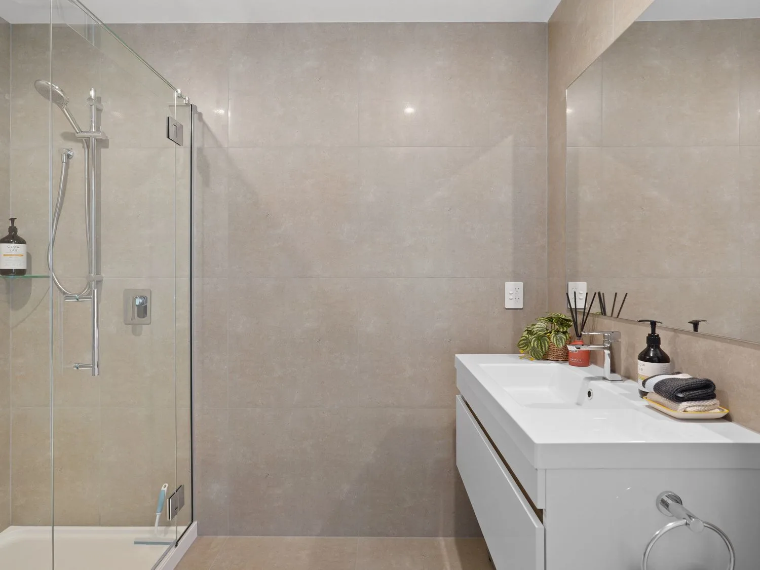 Un baño con una ducha y un mueble blanco con lavabo.