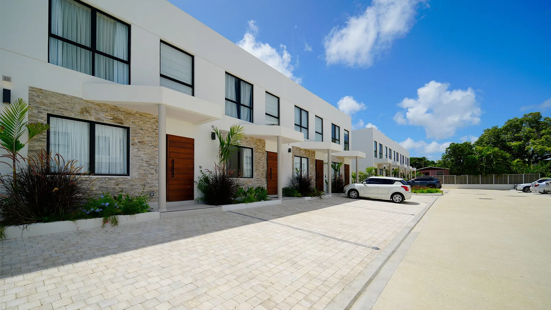 A row of modern two-story buildings faces a paved parking area.