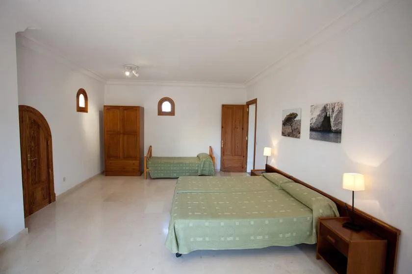 Un dormitorio con dos camas, mesillas de noche y cuadros en la pared.