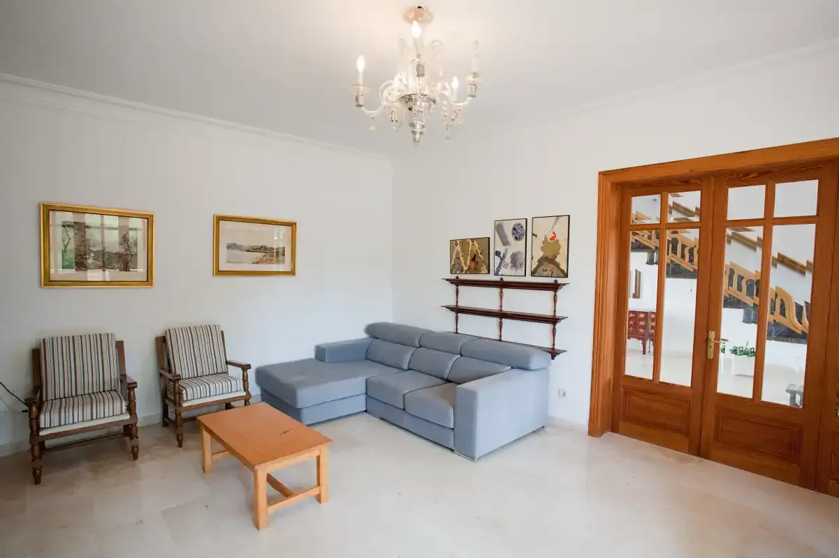 Una sala de estar con un sofá esquinero, sillones y una mesa de centro de madera.