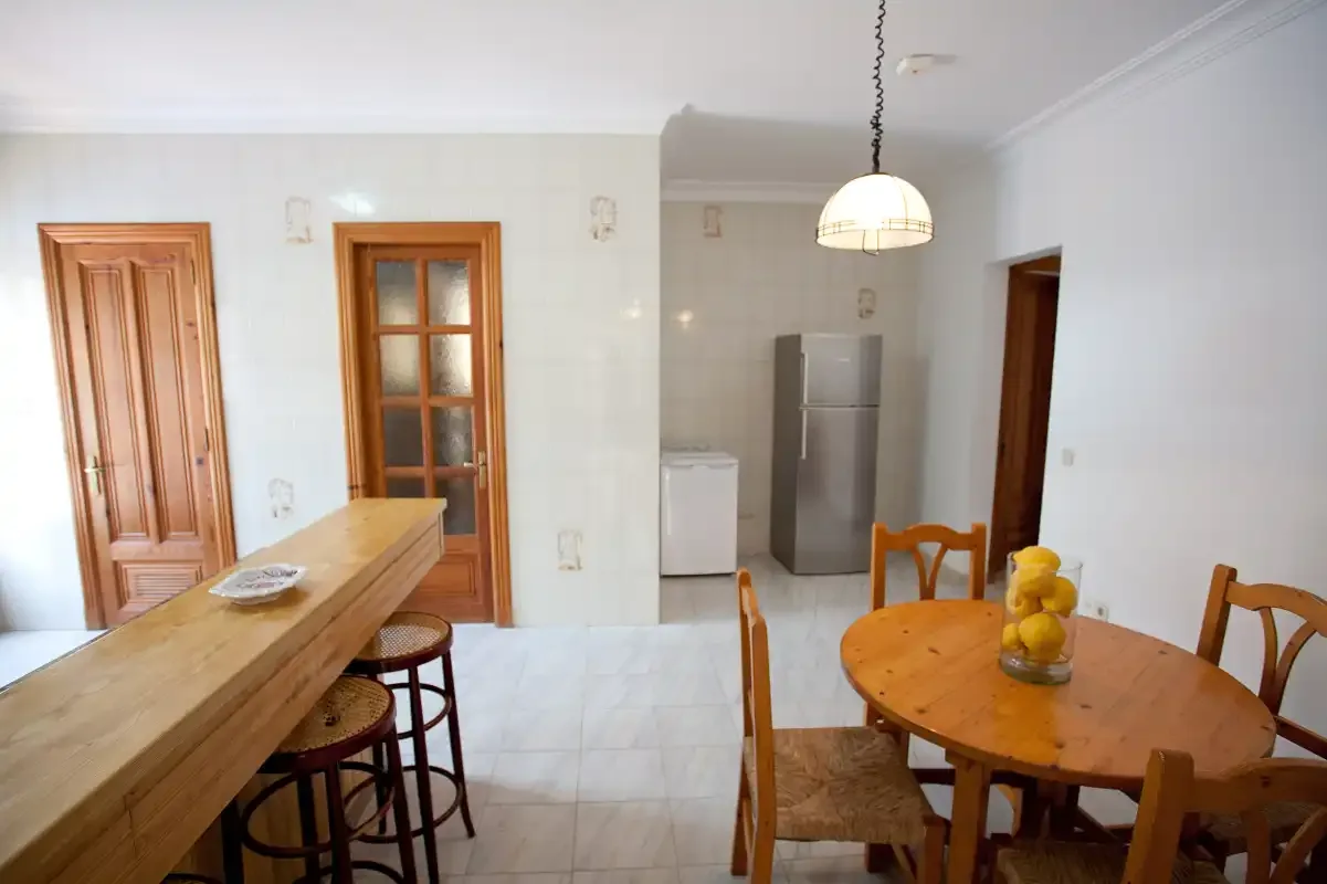 Un comedor con una mesa de madera y una encimera de cocina.
