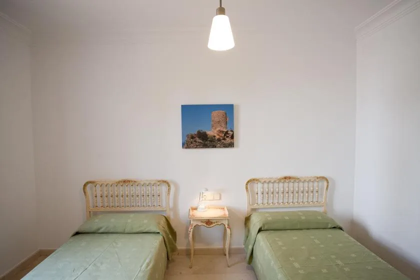 Un dormitorio con dos camas individuales y una mesita entre ellas.