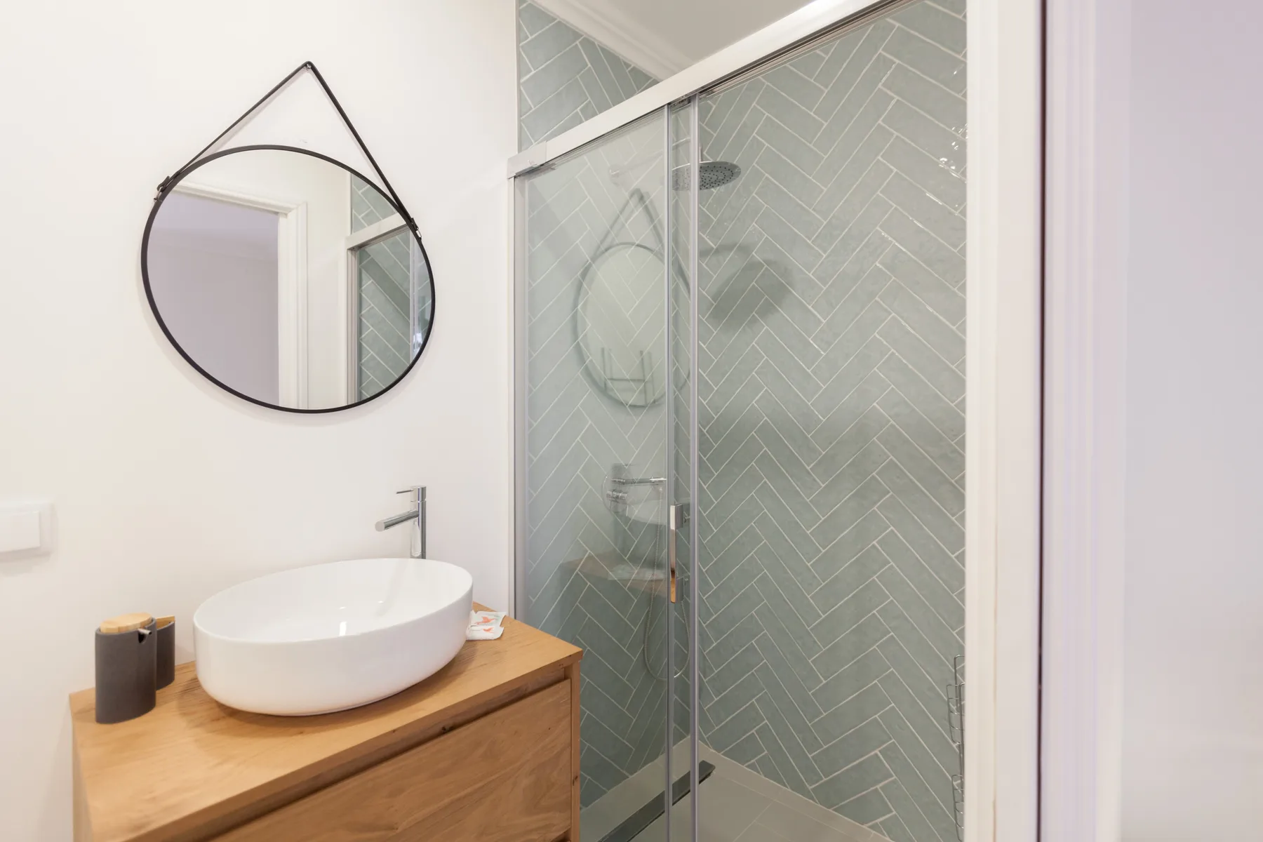 A bathroom with a vessel sink and glass-enclosed shower.