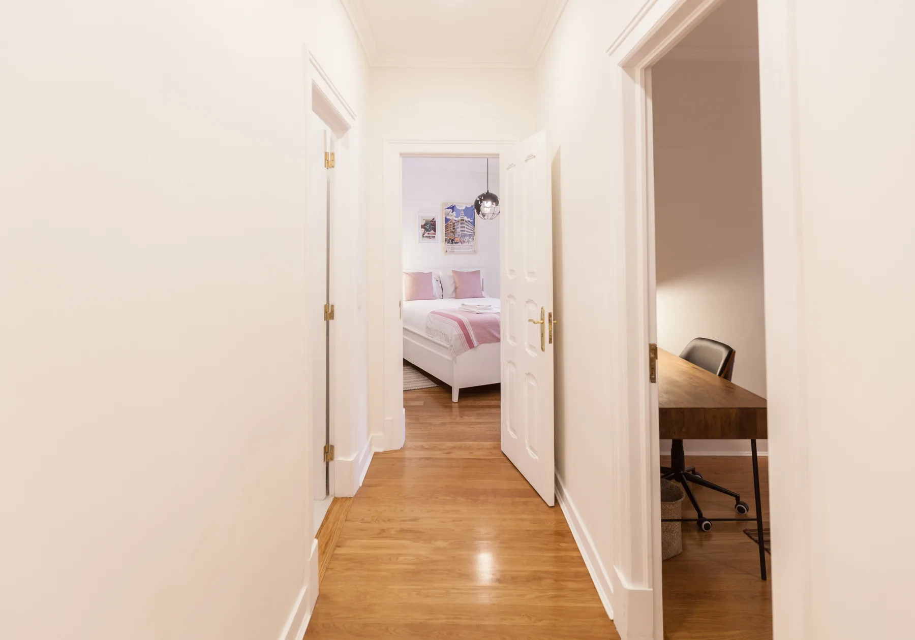 A bright hallway leads to a bedroom and a small office.