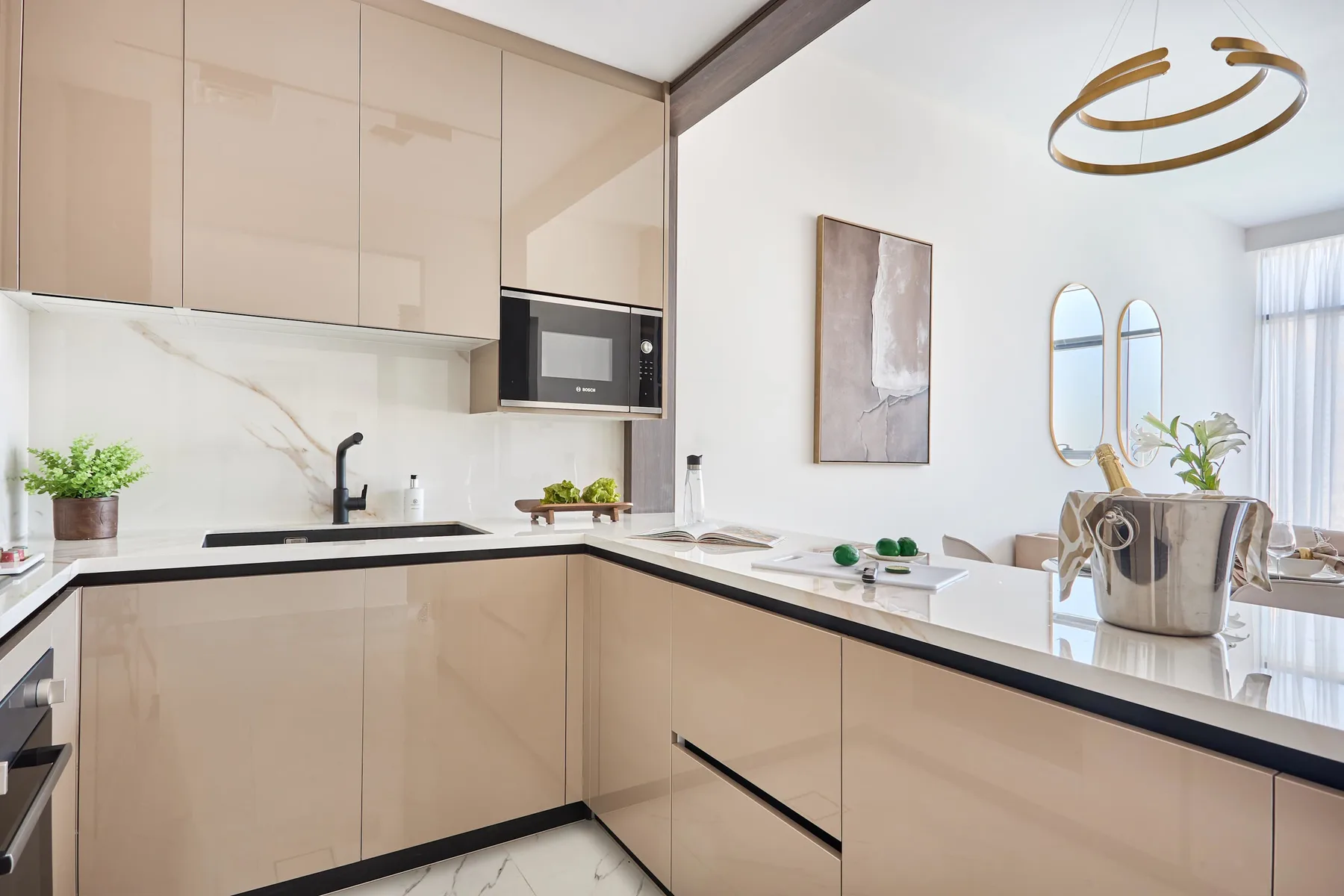 Una cocina moderna con gabinetes claros, encimeras oscuras y zona de comedor.