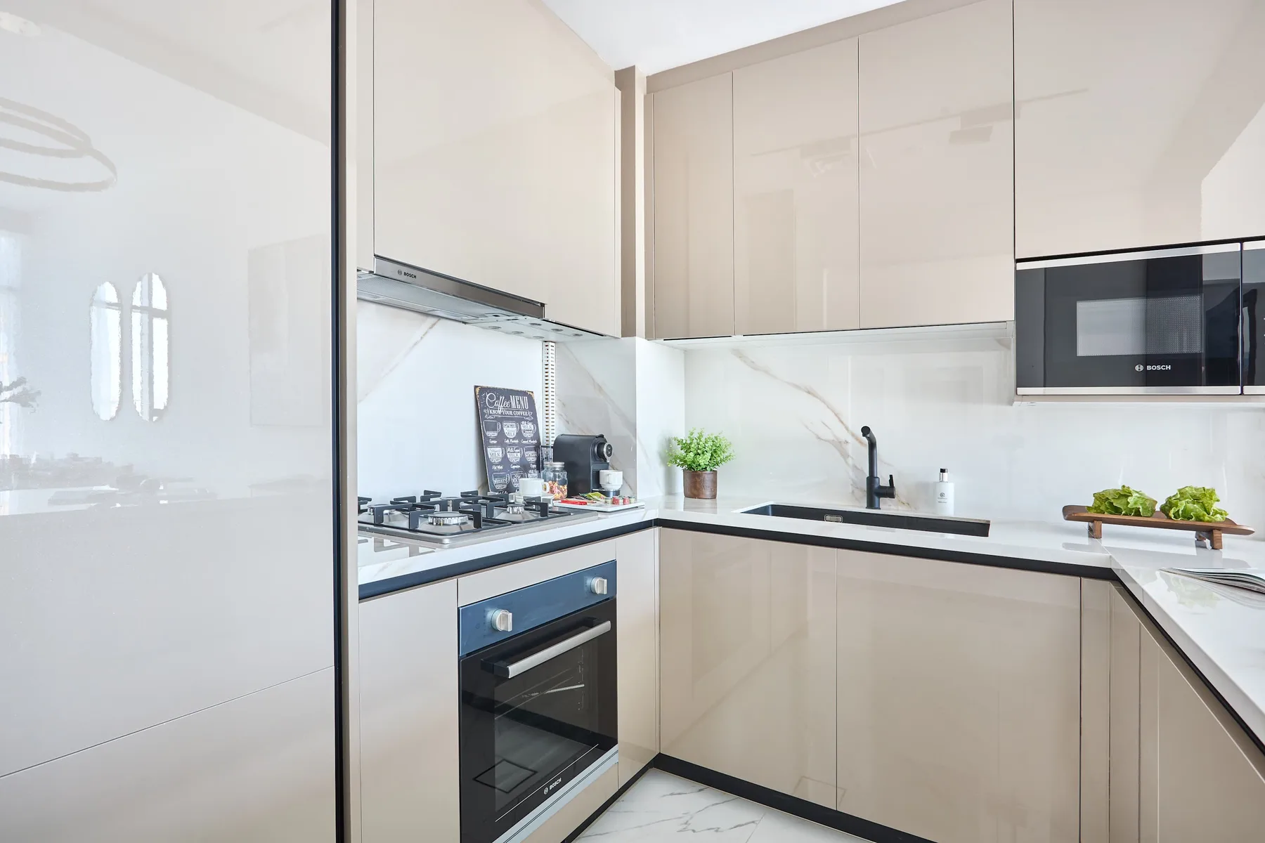Una cocina moderna y luminosa con gabinetes claros, una placa de cocción y un horno.