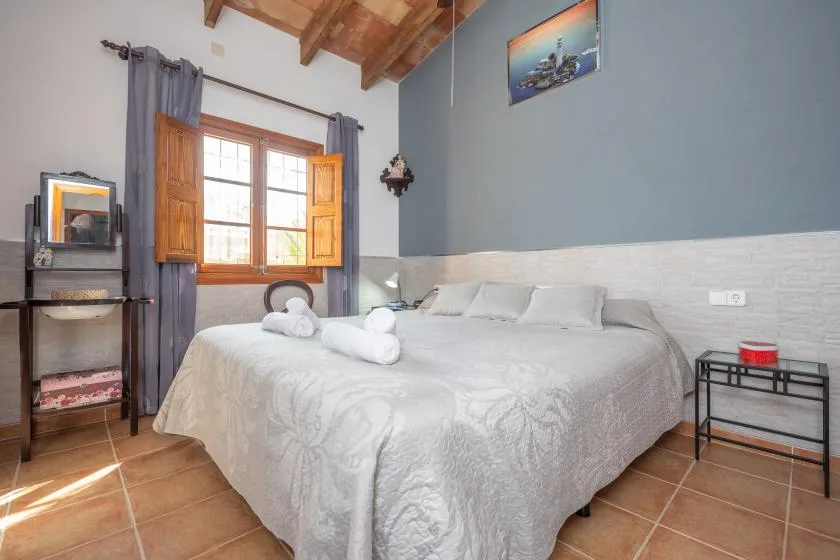 Un dormitorio con una cama grande bajo un techo con vigas de madera.
