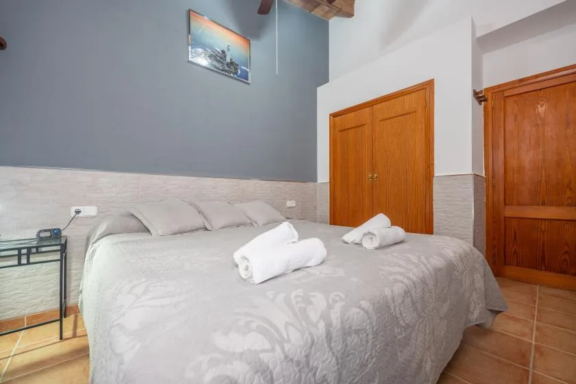 Un dormitorio con una cama grande, toallas dobladas y puertas de madera.