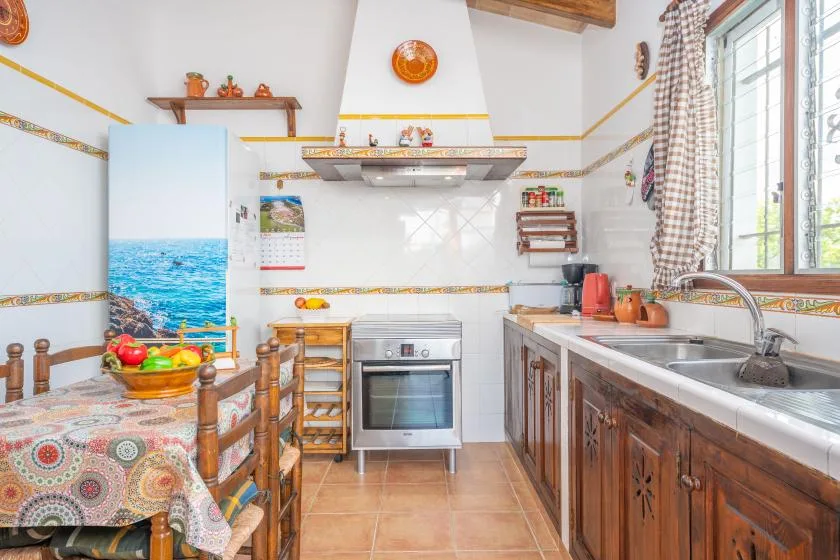 Una cocina luminosa con mesa de comedor, cocina y fregadero.