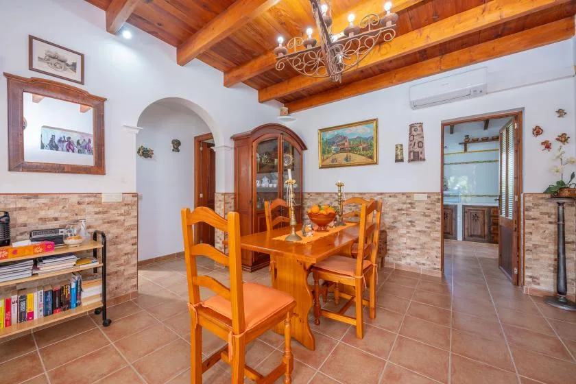 Un comedor con una mesa y sillas de madera bajo vigas expuestas.