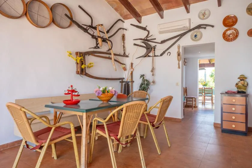 Un comedor con una mesa y asientos bajo objetos decorativos en las paredes.