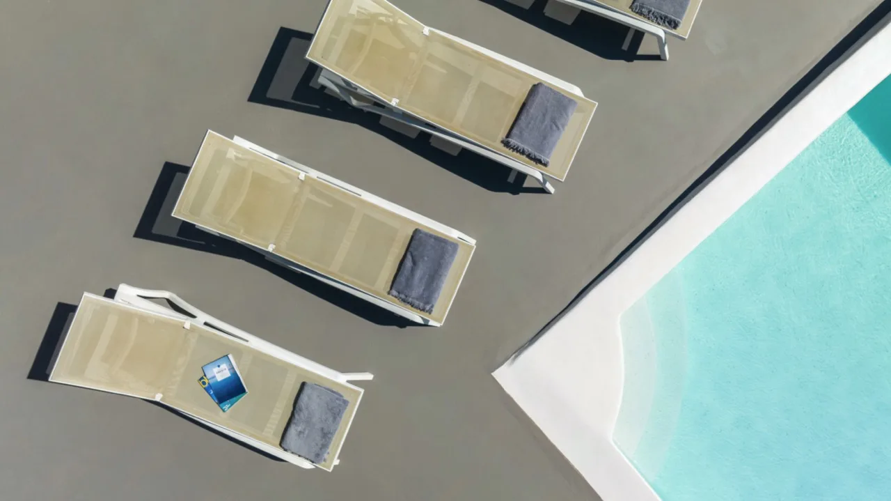 An overhead view of lounge seating beside a swimming pool.