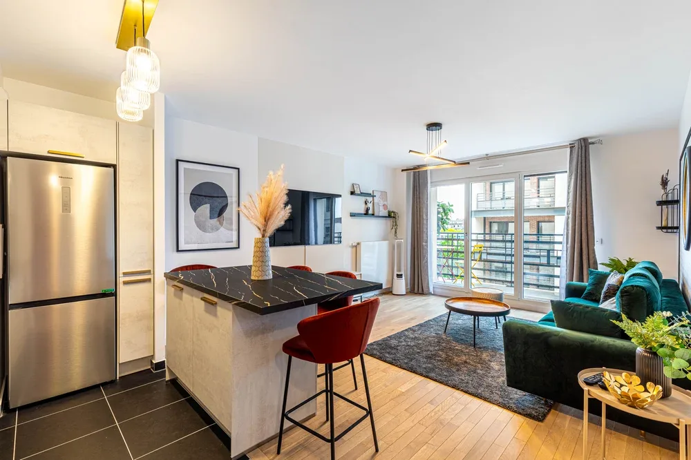 Una sala de estar y cocina de concepto abierto con una isla y ventanas grandes.