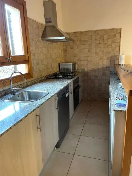 Una cocina estrecha con fregadero, encimera y estufa.