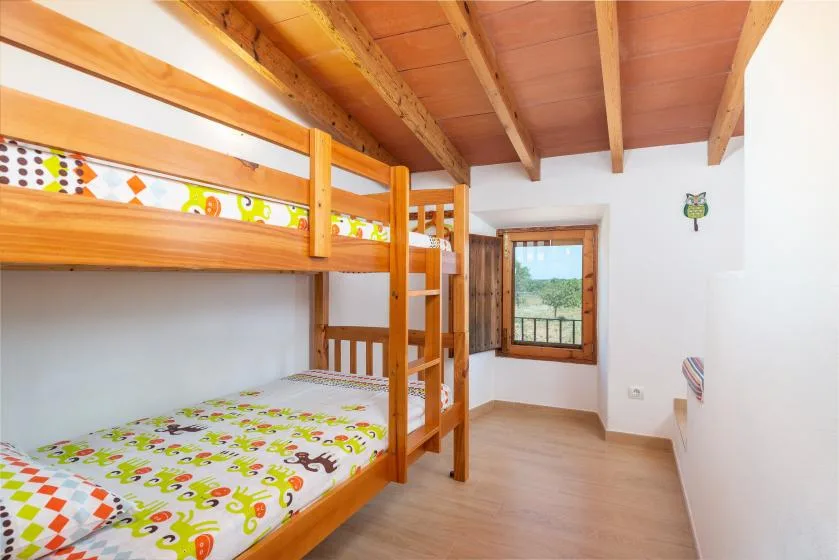 Un dormitorio con una litera de madera y ropa de cama estampada y colorida.