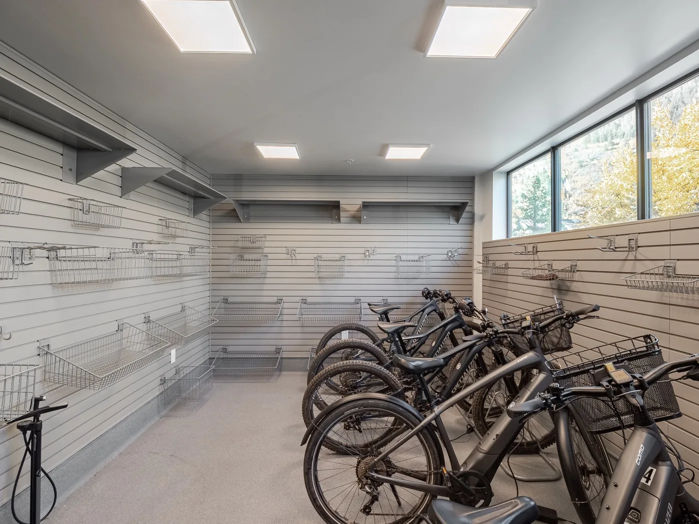 A bicycle storage room with several bicycles parked beside the wall.