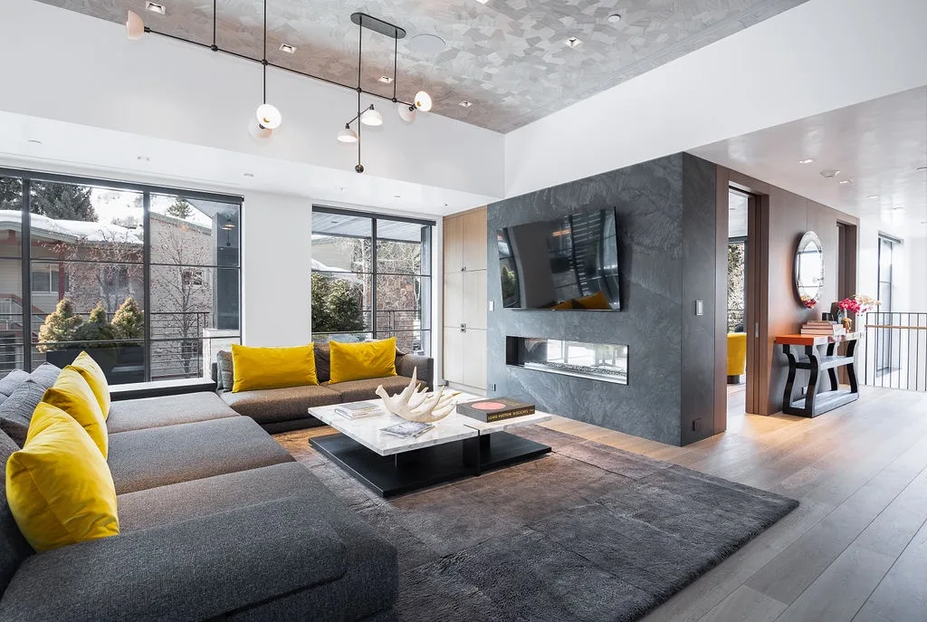 A modern living room with a sectional seating area and a wall-mounted television.