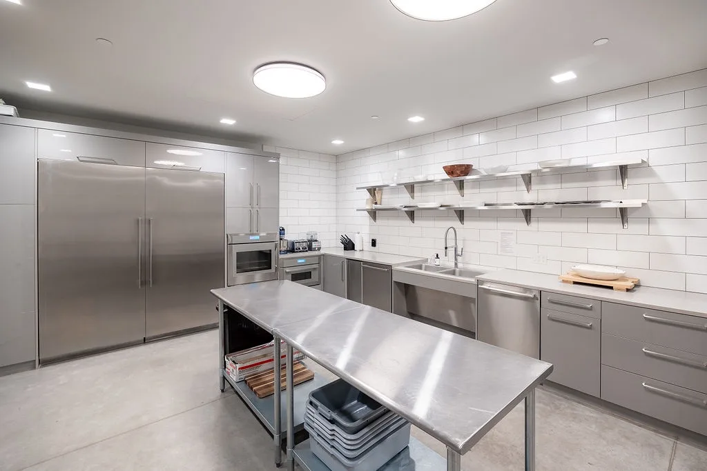 A spacious kitchen with stainless steel appliances and a central worktable.