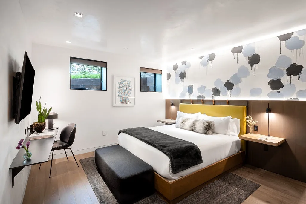 A bedroom with a large bed and a small desk area.