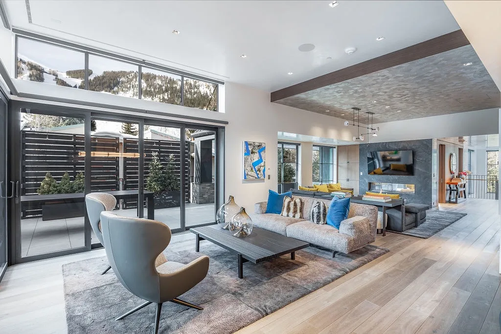 A bright living room with seating arranged around a coffee table and large glass doors.