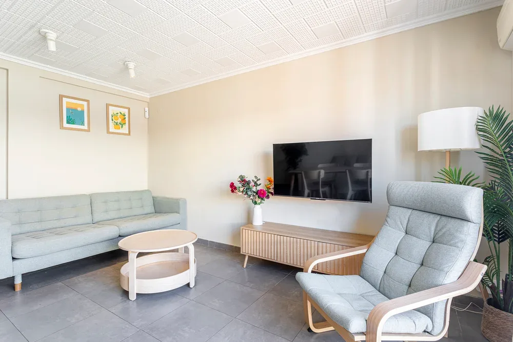 A living room with seating, a television, and a round coffee table.