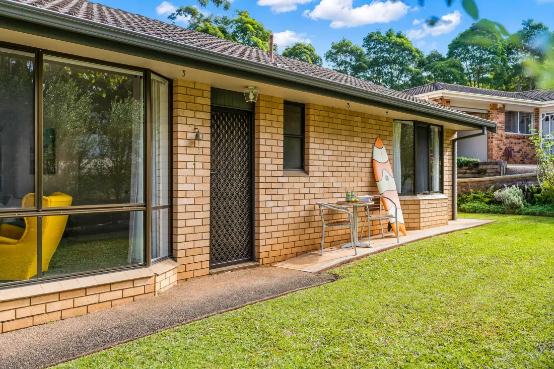 Brick house exterior with sliding glass doors and a grassy yard.
