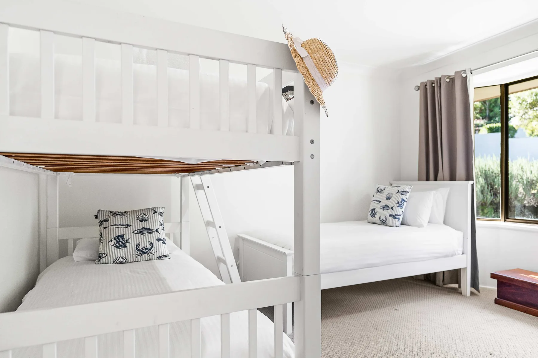A bright bedroom with bunk beds and a large window.