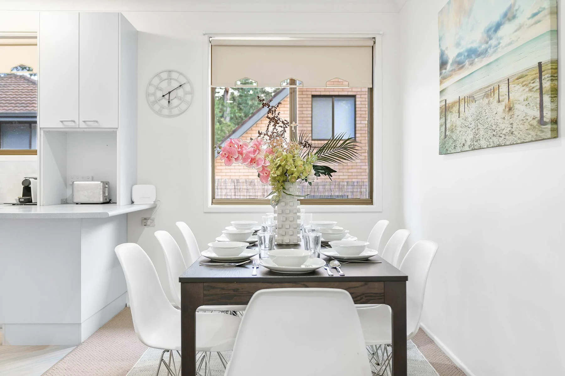 A bright dining area with a table set beside a large window.