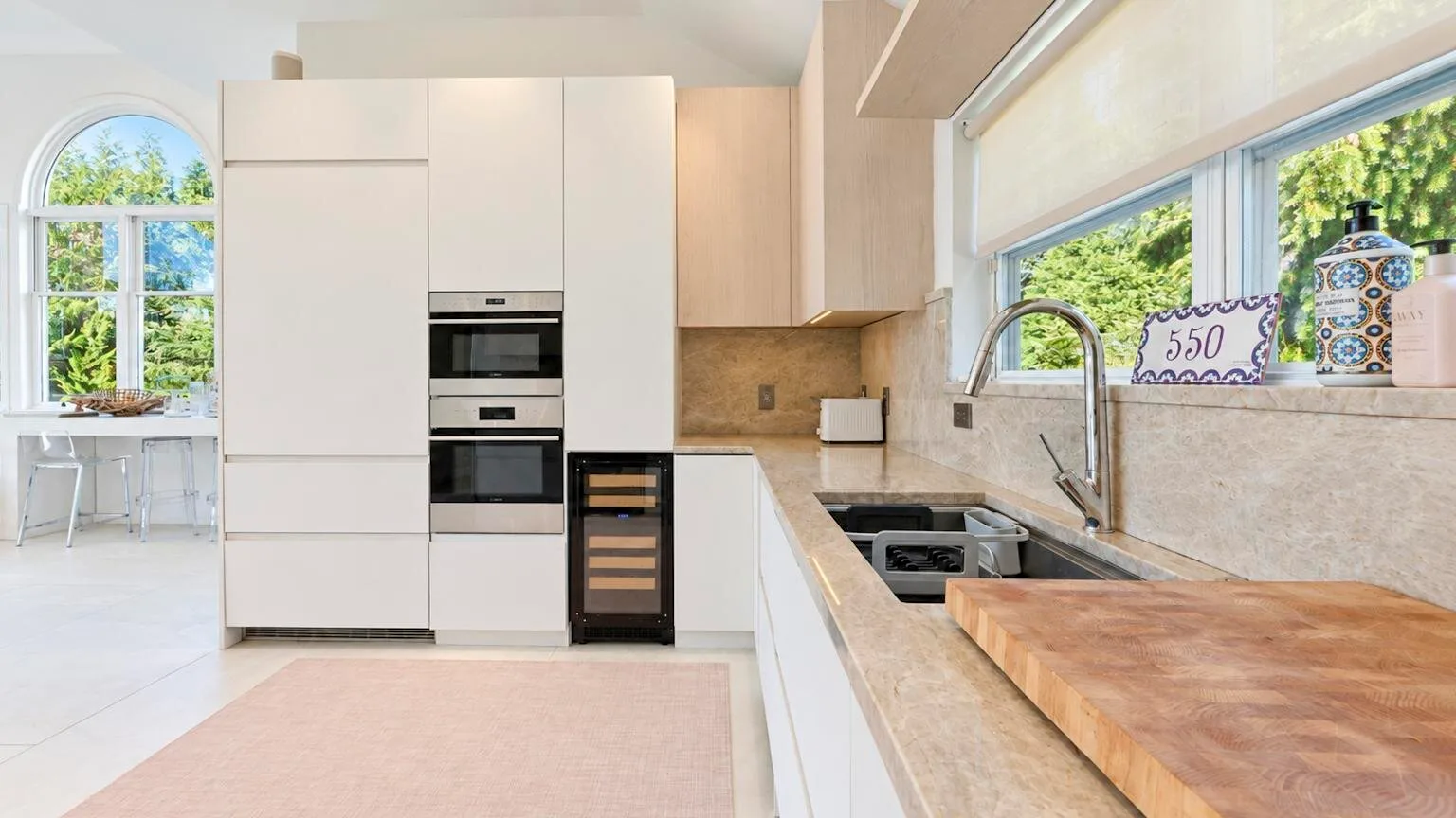 Una cocina moderna y luminosa con gabinetes blancos y una isla grande.