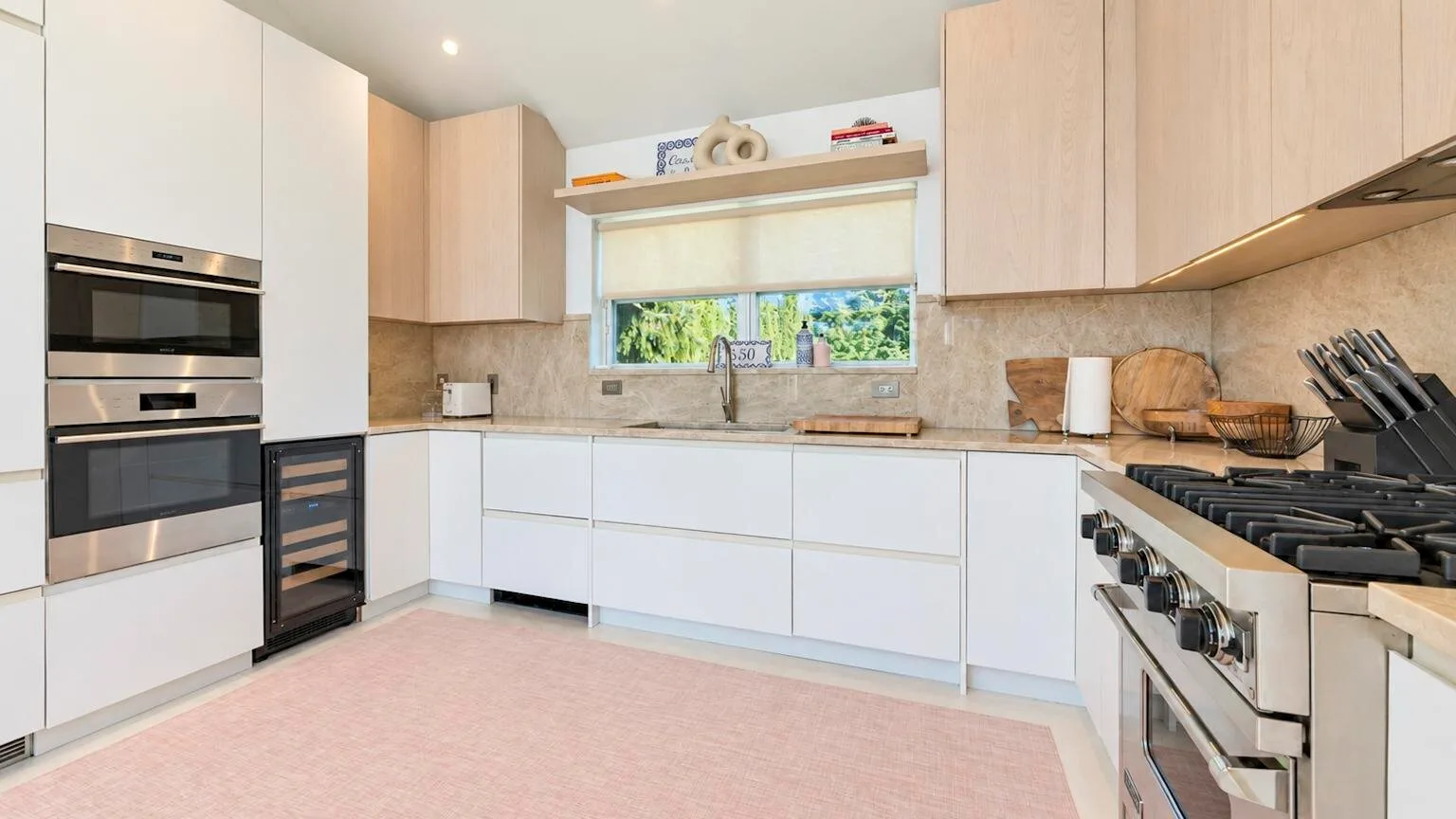 Una cocina moderna y luminosa con gabinetes blancos y una amplia encimera.